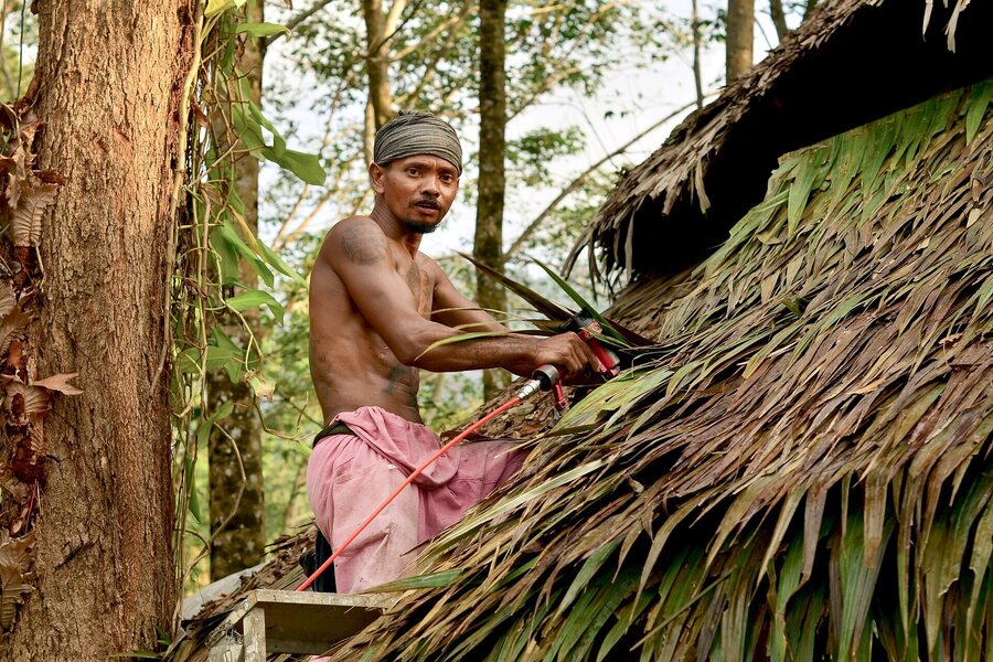 Craftsperson repairing a traditional bamboo roof in Thailand (specific locality not supplied by the photographer)